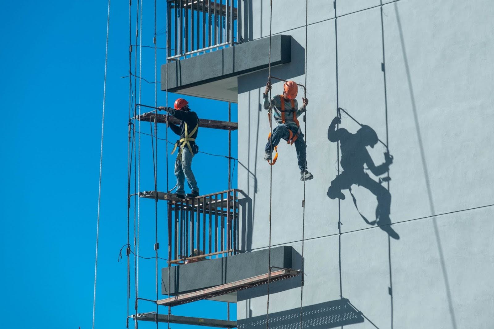 Singapore workers working on a high rise building using ropes